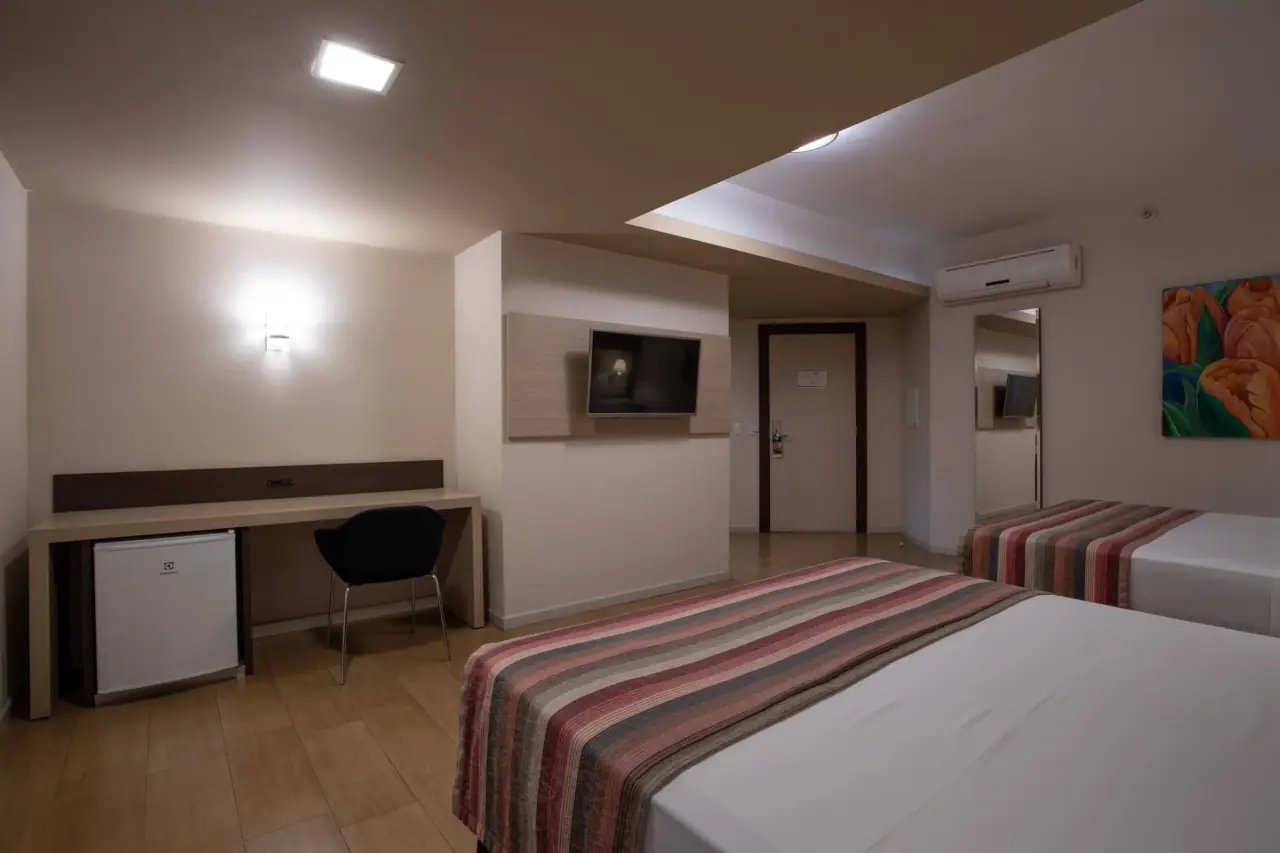 Room with striped bedspread and desk