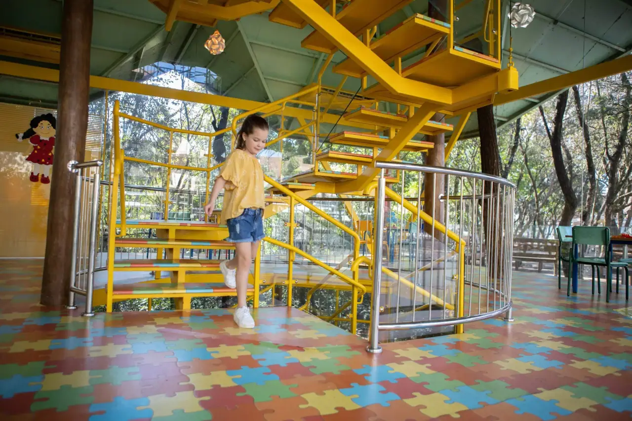 Criança em brinquedo de escalar na área kids