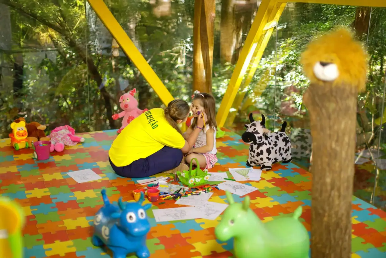 Kids-club counselor playing with a child in a colorful play area