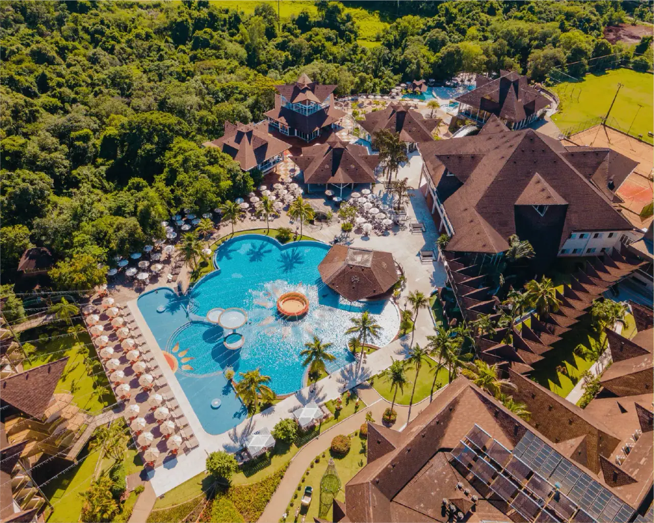 Resort pools seen from above among palm trees